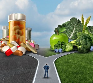 Medication decision concept and natural remedy nutrition choices dilemma between healthy fresh fruit and vegetables or pharmaceutical pills and prescription drugs with a man on a crossroad trying to decide the best path to health.
